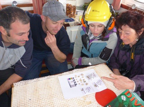 Figure 6. Prof. Karen Hardy from ICREA, Barcelona (far right) showing SAMPHIRE team members Bob MackIntosh (far left), Drew Roberts (middle-left), Chelsea Colwell-Pasch (middle-right) lithics found on her coastal survey of Eigg (Photo by: Jonathan Benjamin).